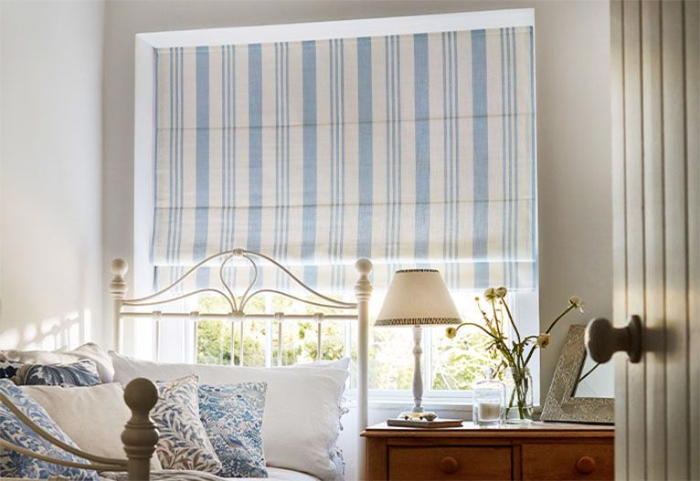 Blue and cream striped Roman blinds in a bedroom