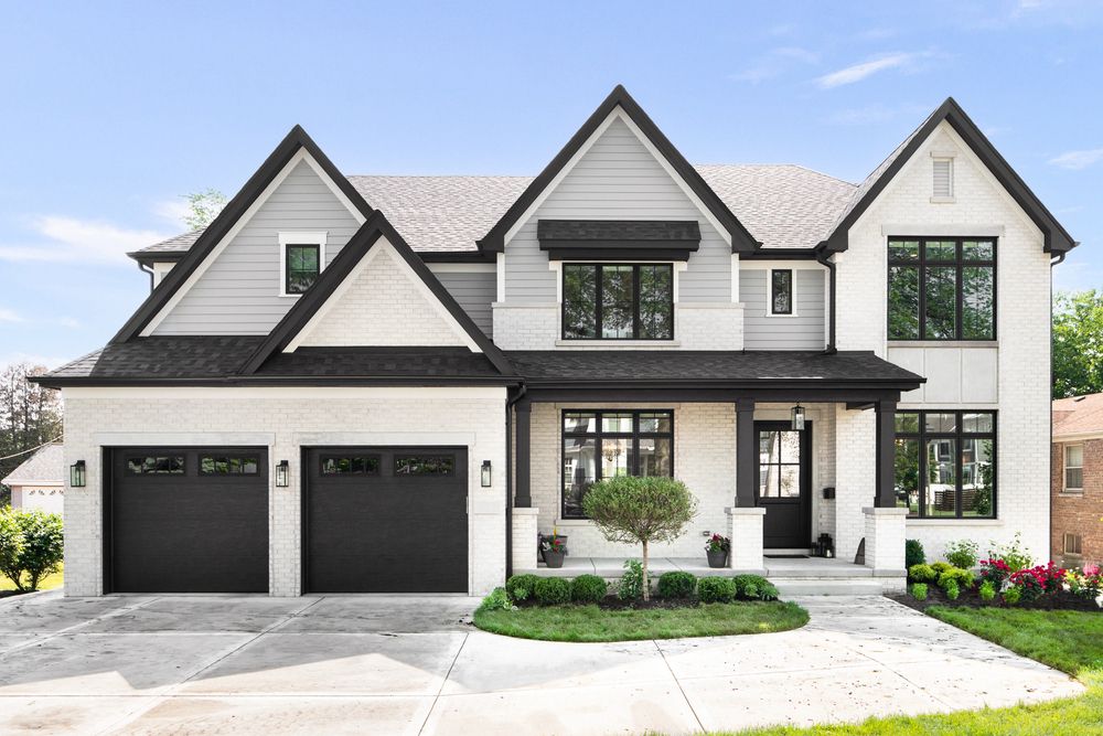 Black windows on a white brick house with a double garage
