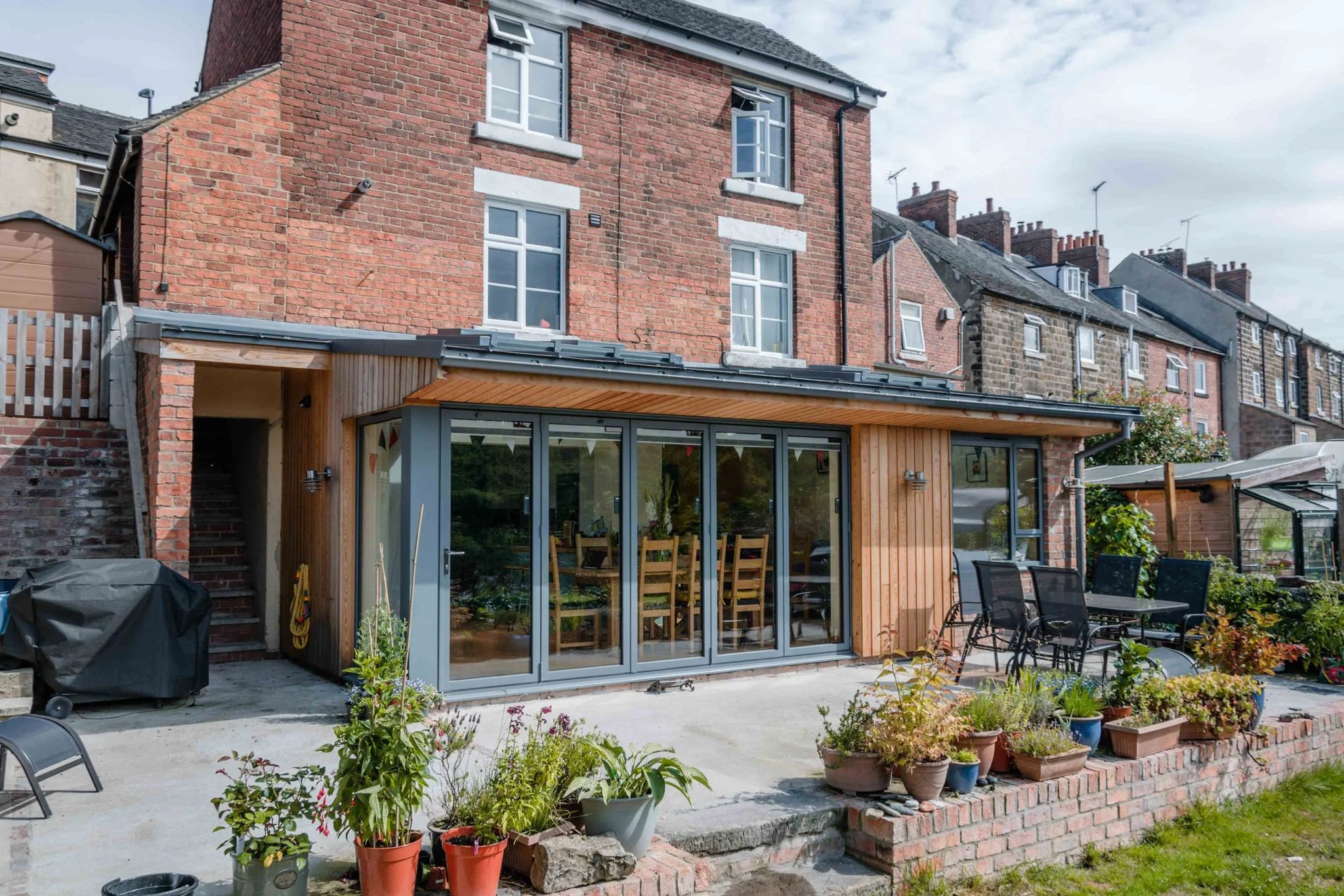 Grey bifold doors on a timber-clad rear extension