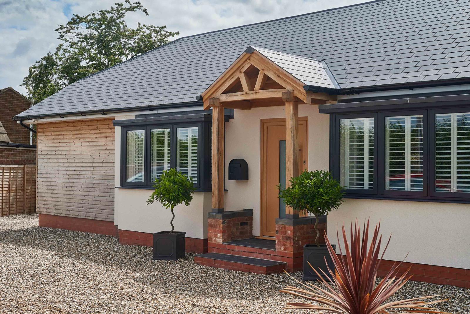 Anthracite windows on a cream bungalow with an oak porch